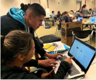 Students looking at laptop