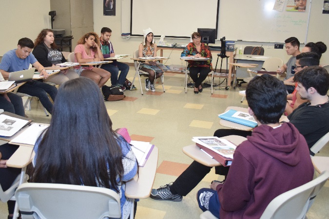 A circle of students discussing course material in their classroom.