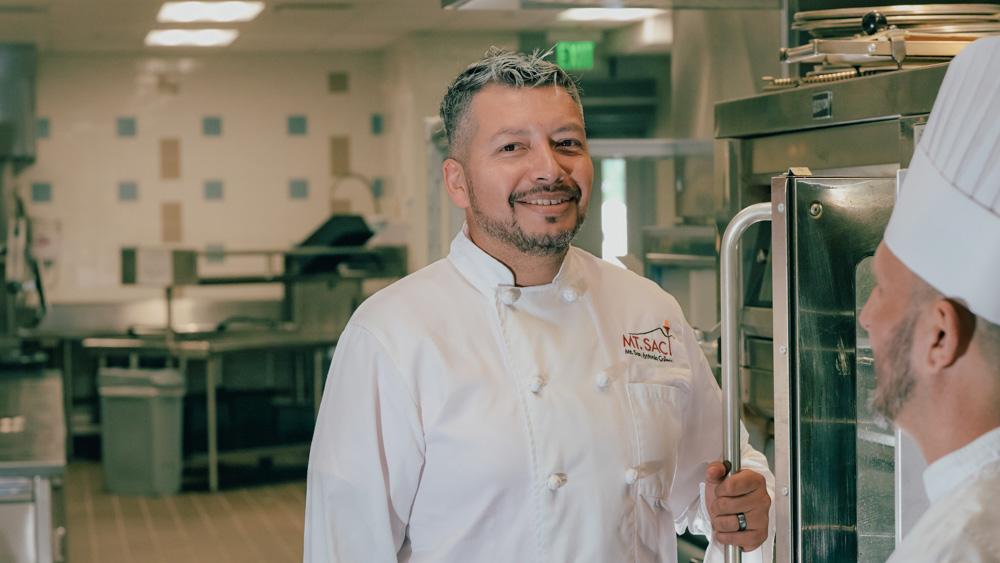 Noe Torres talks with a lab tech in Mt. SAC's commercial production kitchen.