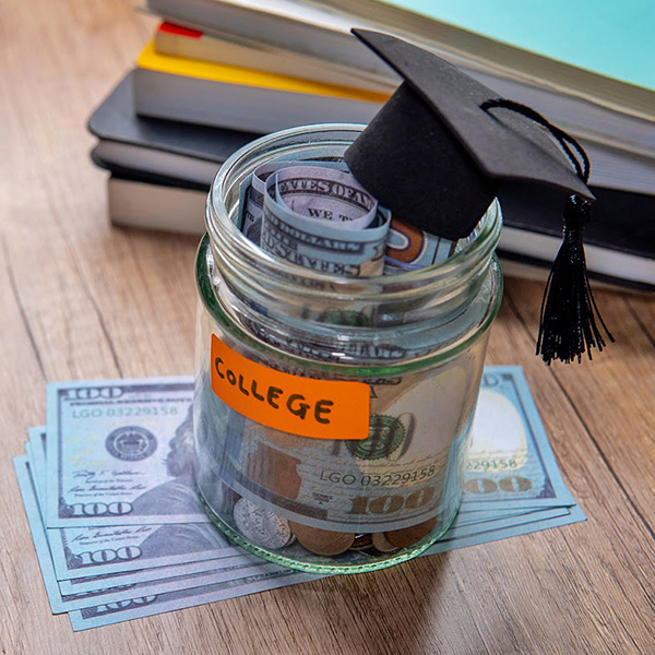 A jar labeled for college funds with a graduation cap on top of it.