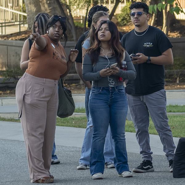 A volunteer points students in the right direction on campus.
