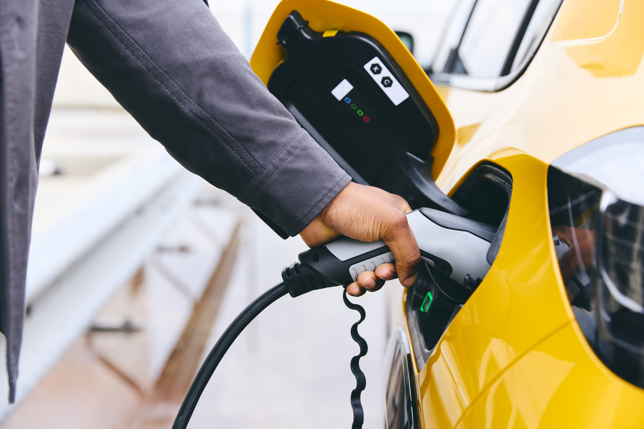 Man's hand on electric vehicle charger